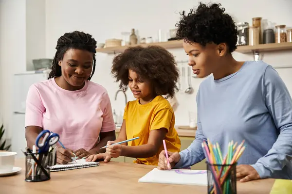 Dos padres participan en actividades creativas con su hija, compartiendo alegría y risas juntos. - foto de stock