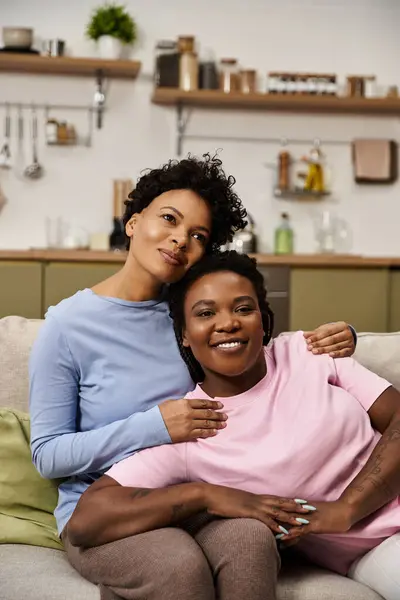 Two women share a heartfelt embrace in a cozy living room setting. — Stock Photo