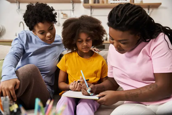 Two mothers and their daughter share an artistic and joyful bonding experience together. — Stock Photo