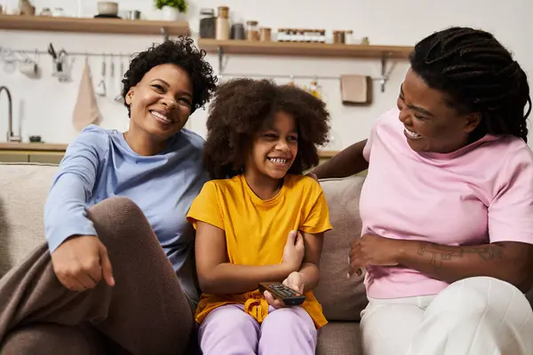 Two joyful parents sharing a lighthearted moment with their daughter in a warm and inviting room — Stock Photo