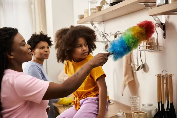 A cheerful family engages in a fun cleaning activity, sharing smiles and laughter while bonding. — Stock Photo