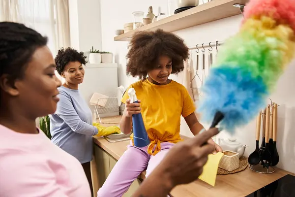 Una familia lgbt cariñosa se dedica a la limpieza juguetona mientras comparte la risa en su cocina soleada. - foto de stock