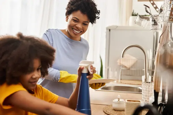 A joyful family moment as a daughter helps her parent with chores in their sunny kitchen. — Stock Photo
