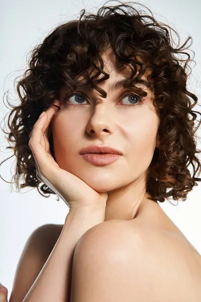 Curly haired young woman showcases natural beauty with an elegant pose and soft expression — Stock Photo
