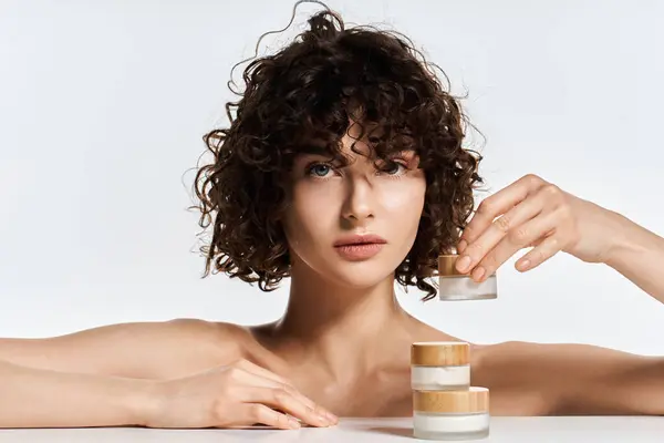 Young woman with stunning curls engages in skincare routine, showcasing natural beauty. — Stock Photo