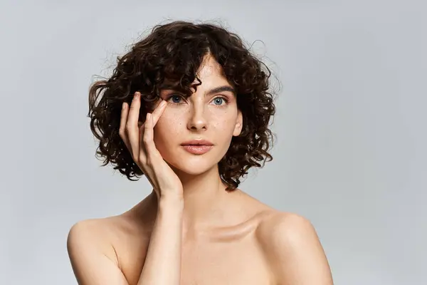 Une jeune femme aux cheveux bouclés et aux yeux bleus incarne l'élégance naturelle. — Photo de stock