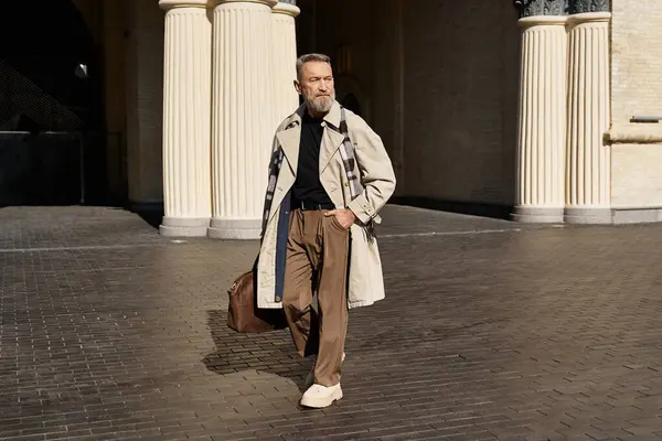 A dapper senior man strolls through a contemporary cityscape, clad in fashionable clothing. — Stock Photo
