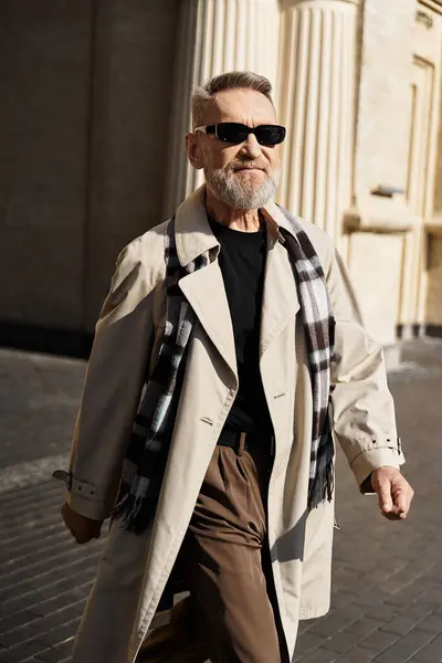 Un uomo anziano passeggia attraverso il paesaggio urbano, mostrando il suo stile elegante in un abito contemporaneo. — Foto stock