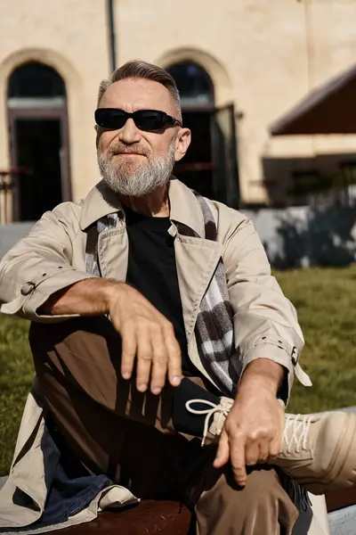 A fashionable senior man sits with a relaxed demeanor, showcasing his trendy attire. — Stock Photo