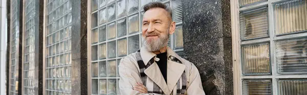 A handsome senior man strolls through a contemporary city, showcasing his style. — Stock Photo