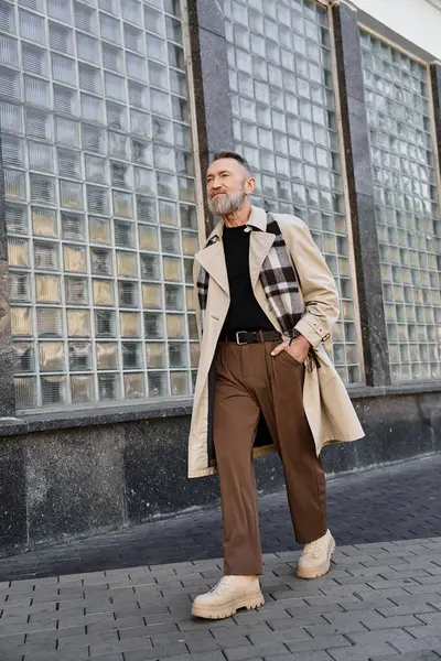 Un uomo anziano dissoluto passeggia nel paesaggio urbano, indossando un abbigliamento chic. — Foto stock