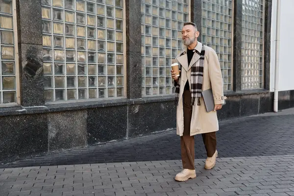 A handsome senior man strolls through a modern urban landscape, dressed in trendy attire. — Stock Photo