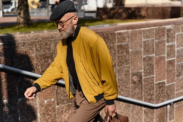 A dapper senior man strides through an urban environment, showcasing his contemporary fashion. — Stock Photo