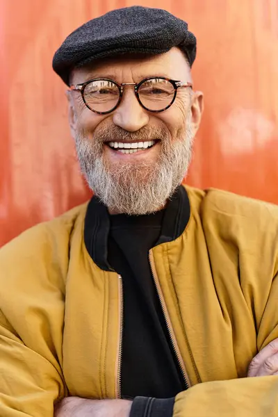 A dapper senior man showcases his trendy style as he stands confidently against a bright city wall. — Stock Photo