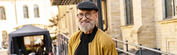 A stylish senior man strolls through an urban landscape, showcasing contemporary fashion. — Stock Photo