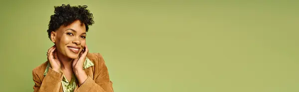 A lovely african american woman showcases her trendy outfit while posing with a warm smile indoors. — Stock Photo
