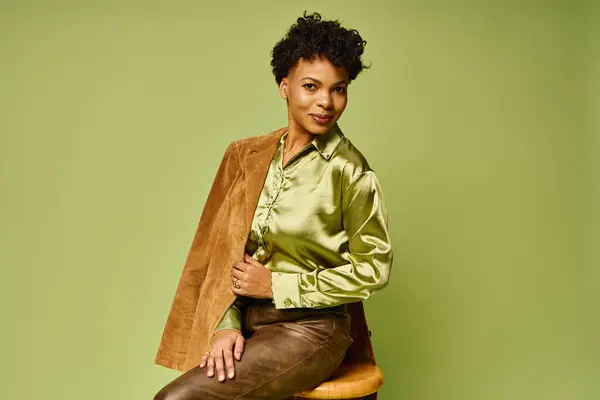 A beautiful african american woman poses confidently in a chic outfit, radiating modern elegance. — Stock Photo