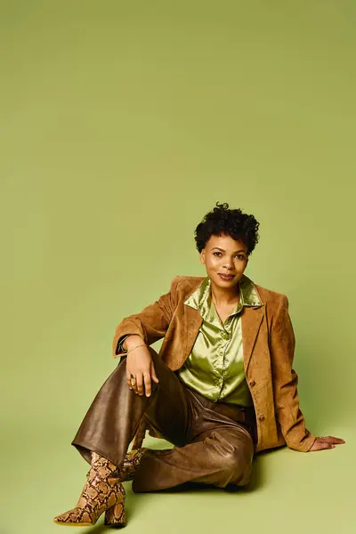 Una hermosa mujer afroamericana posa elegantemente en un atuendo elegante, irradiando confianza y estilo. - foto de stock