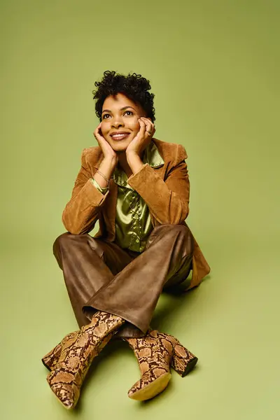 Fashionable african american woman sits elegantly, showcasing her chic style and radiant smile. — Stock Photo