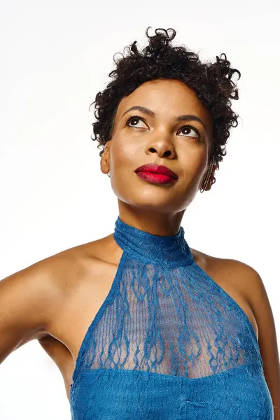 A stylish African American woman showcases her beauty in a trendy blue ensemble with bold makeup. — Stock Photo