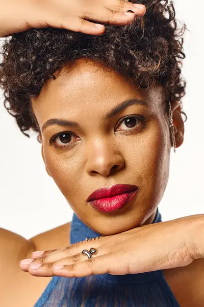A stylish African American woman poses confidently, showcasing her chic look and bold makeup. — Stock Photo