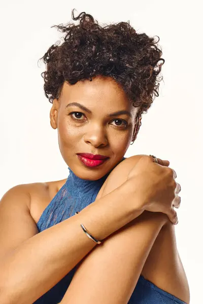 A stylish African American woman poses confidently in chic blue attire, radiating charm. — Stock Photo