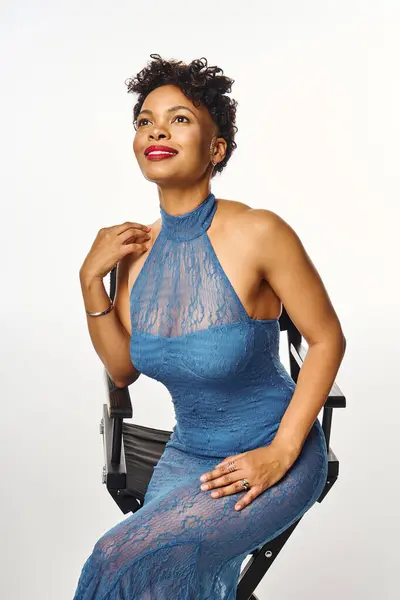 A chic African American woman poses confidently in a modern blue lace dress. — Stock Photo