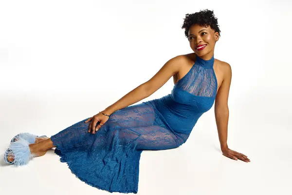 Confident African American woman poses gracefully in a contemporary blue lace dress. — Stock Photo