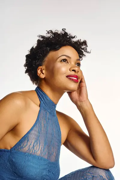 A confident African American woman poses in stylish blue attire with a radiant smile. — Stock Photo
