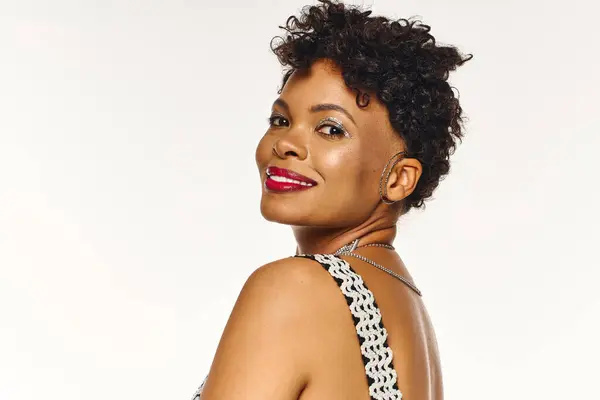 A fashionable african american woman shows off her smile and trendy hairstyle in chic attire. — Stock Photo