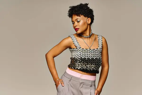 Confident African American woman poses in a trendy outfit against a neutral backdrop. — Stock Photo