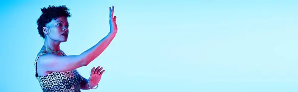 Trendy woman expresses her unique style and confidence while posing in a colorful setting. — Stock Photo