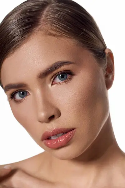 A chic young woman with stunning features highlights her elegance and beauty in soft lighting. — Stock Photo