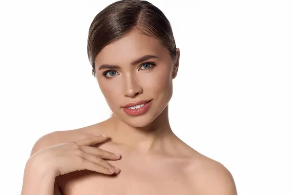 A stylish young woman with a radiant smile gently poses with grace against a minimal background. — Stock Photo