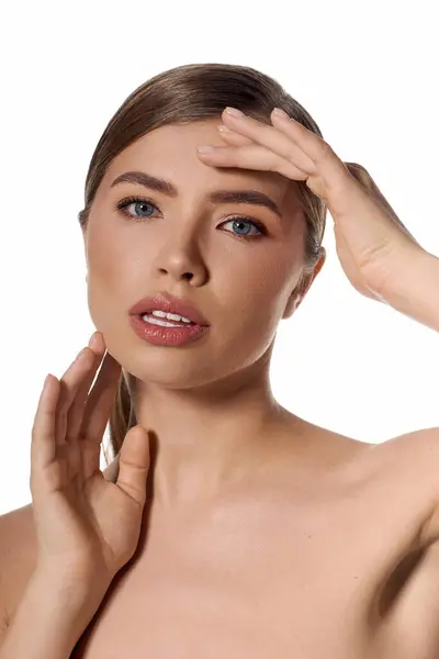 Eine junge, elegante Frau berührt ihr Gesicht und präsentiert ihren schicken Stil in einem hellen Ambiente. — Stock Photo