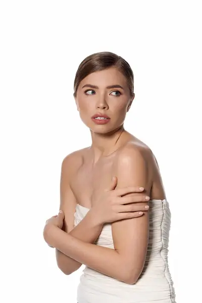 A young woman stands gracefully, showcasing her chic elegance against a minimalist backdrop. — Stock Photo