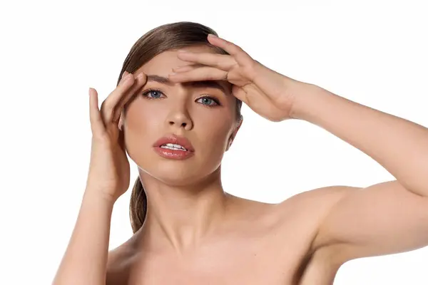Beautiful young woman elegantly poses with her hand on her forehead, exuding confidence and style. — Stock Photo