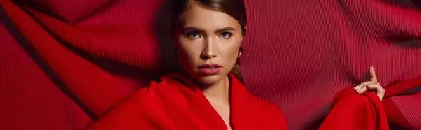 Chic young woman showcases her fashion sense wrapped in red fabric, radiating beauty and elegance. — Stock Photo