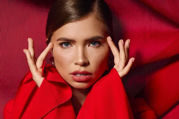 A beautiful young woman poses confidently in a vibrant red ensemble, exuding elegance. — Stock Photo