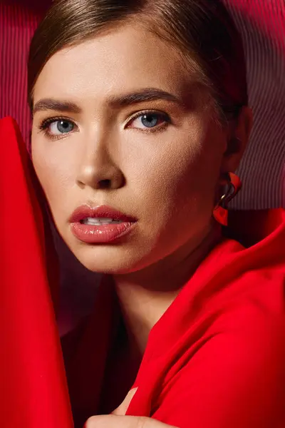 Young woman in vivid red dress elegantly poses, highlighting her beauty and confidence. — Stock Photo
