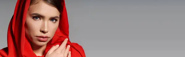 Elegantly dressed woman with a red hood captivates with her stylish look and poised demeanor. — Stock Photo