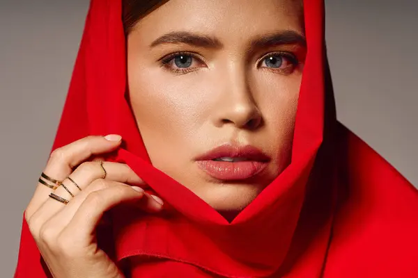 Mujer joven adornada con una bufanda roja capta la atención con su estilo elegante y su comportamiento elegante. - foto de stock
