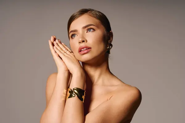 Young woman showcases elegance and beauty while striking a stylish pose in soft lighting. — Stock Photo