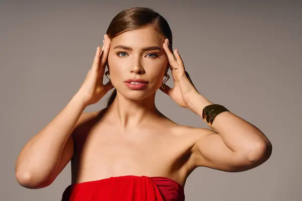 Splendida giovane donna posa con grazia, mostrando eleganza e fiducia in abiti rossi vibranti. — Foto stock