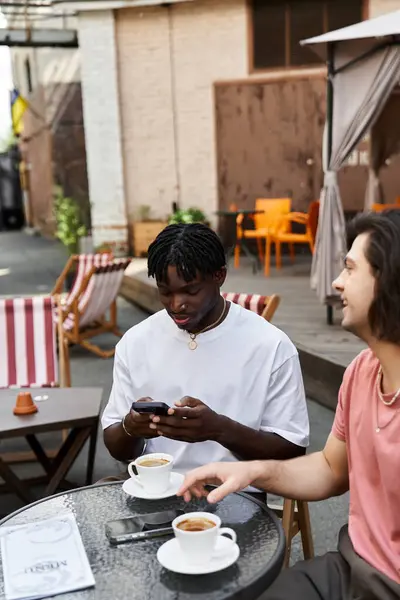 Um casal compartilha sorrisos e risos sobre o café em um café acolhedor. — Fotografia de Stock