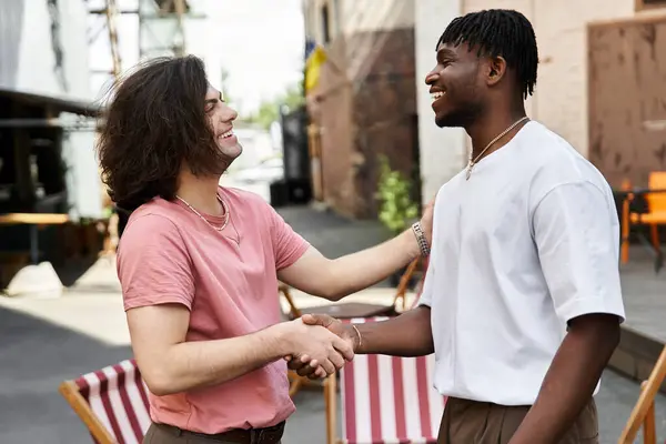 Two handsome men share a joyful moment while on a romantic date in an inviting cafe. — Stock Photo