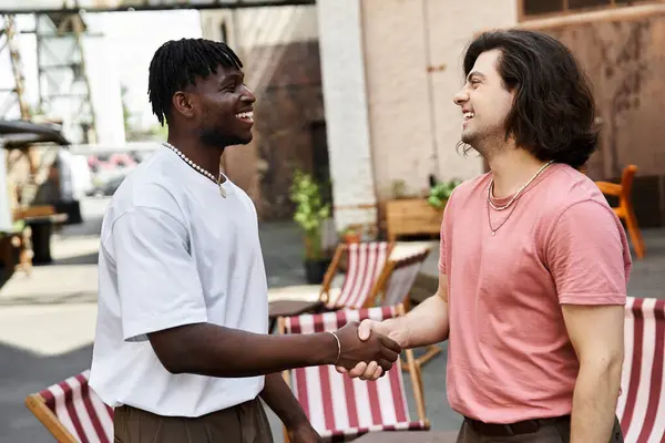 Two affectionate men share smiles and coffee in a lively cafe. — Stock Photo