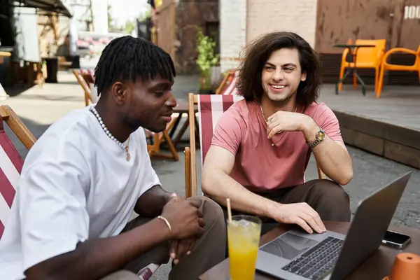 Deux partenaires amoureux partagent un moment spécial à l'extérieur dans un café animé tout en profitant de leurs boissons. — Photo de stock