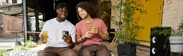 Dois homens bonitos compartilham risos e bebidas em um café encantador, imerso em sua data. — Fotografia de Stock
