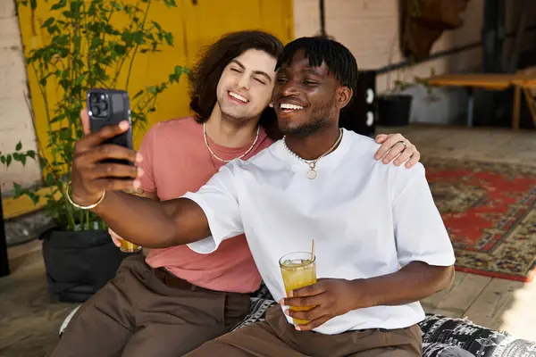 Una pareja cariñosa sonríe brillantemente en un café, compartiendo un momento especial mientras se toman una selfie. - foto de stock